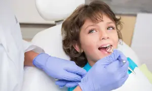 Chłopiec u dentysty, badanie zębów lusterkiem.