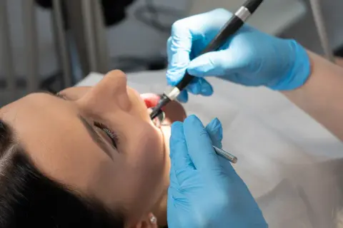 Dentysta bada jamę ustną pacjentki, szukając potencjalnego polipa w zatoce szczękowej.