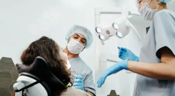 Dentysta bada zęby pacjentki, która ma widoczną dziurę w zębie.