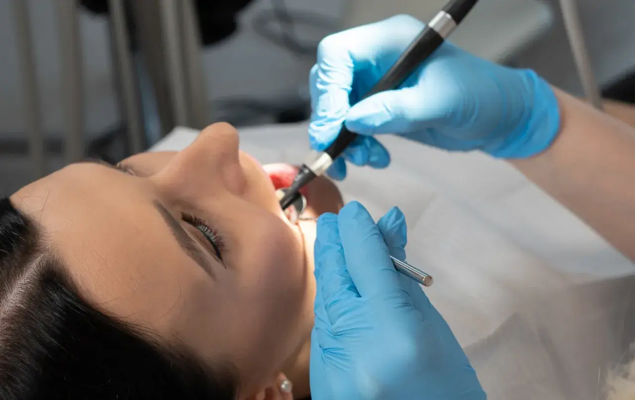 Dentysta bada jamę ustną pacjentki, szukając potencjalnego polipa w zatoce szczękowej.
