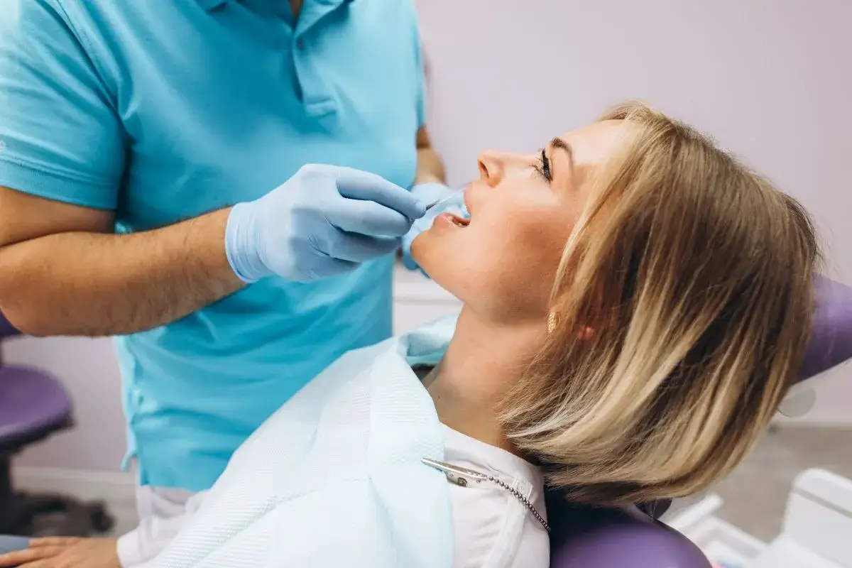 Dentysta bada przyczynę bólu zęba u pacjentki.